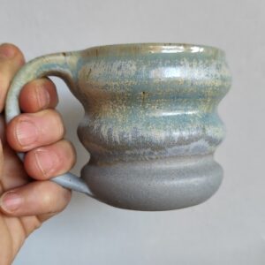 Tazza artigianale in ceramica fatta a mano al tornio con lavorazione ondulata e smalto blu e cenere