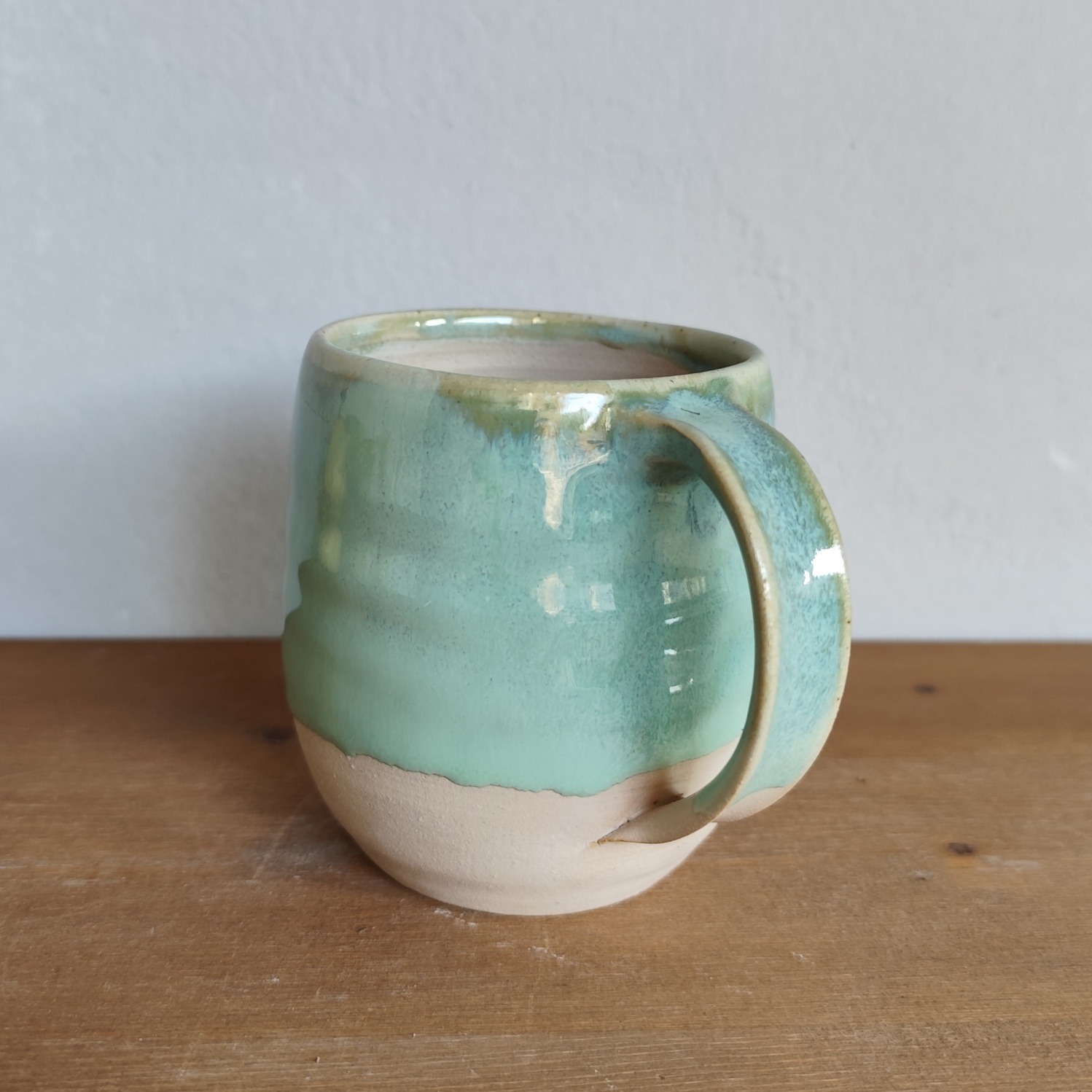 Tazza in ceramica fatta a mano al tornio, smalto verde acqua colato su base in gres a vista
